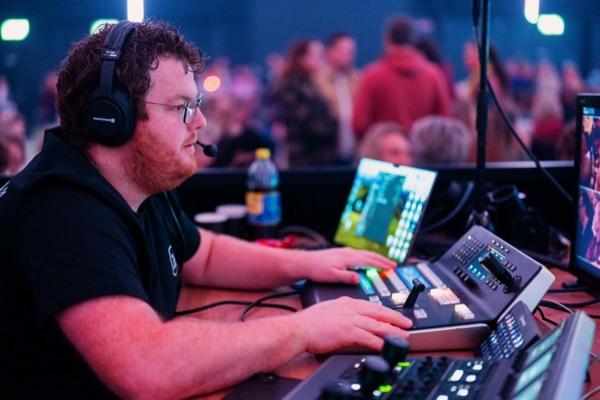 An operator wearing a headset at the control desk.